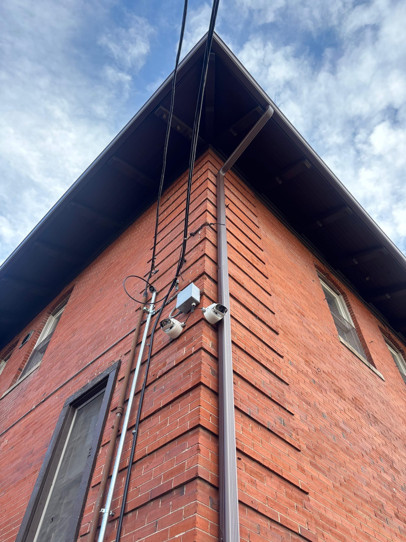 Two bullet cameras installed on a brick building corner