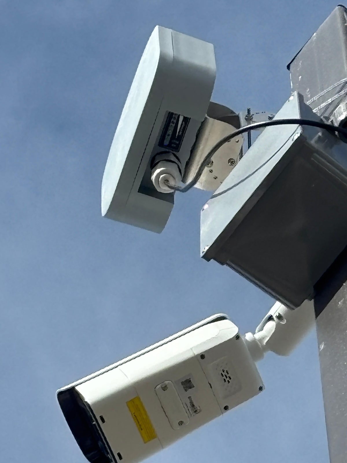 Wireless bridge radio and bullet camera mounted together on a pole bracket