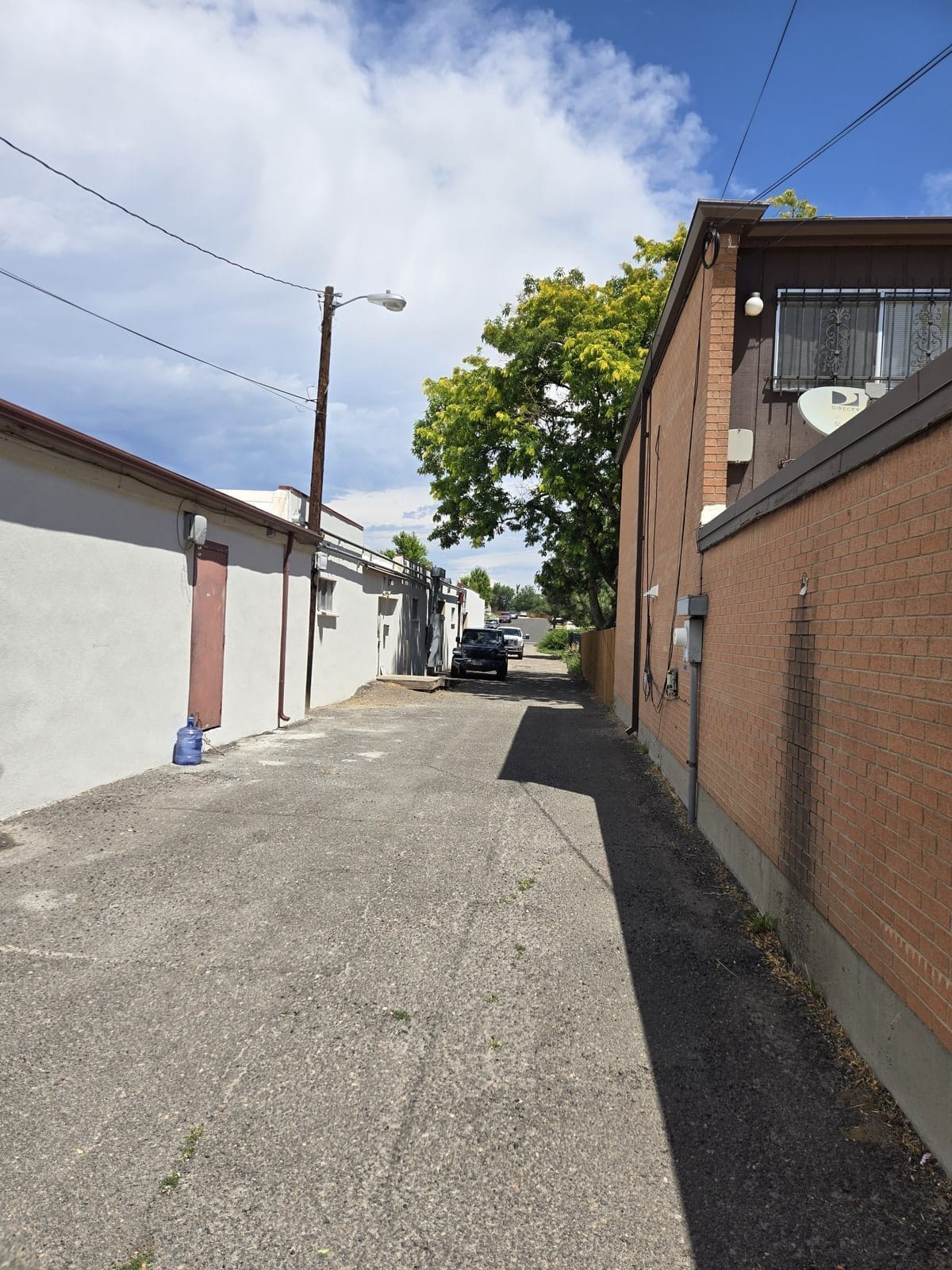 Service alley between campus buildings at Denver Children's Home with a wall-mounted camera and pole light